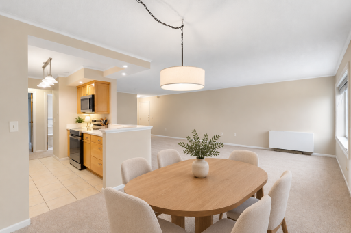 Virtually staged dining area showcasing the open connection between the kitchen, dining, and living spaces, with a spacious layout ready for everyday living and entertaining.