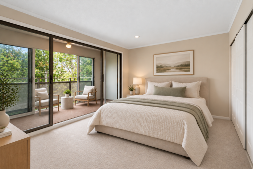 Virtually staged bedroom featuring direct access to the enclosed balcony/sunroom, generous closet space, neutral carpeting, and ample room for a large bed.