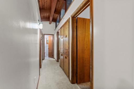 The bedroom hallway continues the home’s unique architectural style with plenty of built-in storage along the way