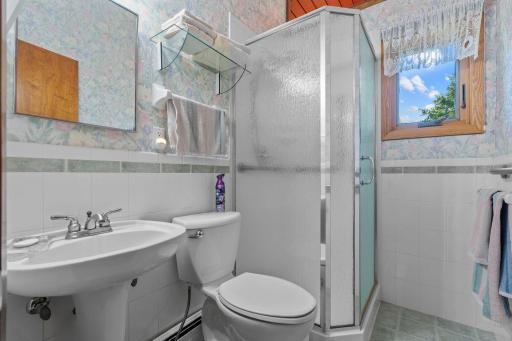 Main level bath just outside the primary bedroom features a walk-in shower and convenient natural light from the window