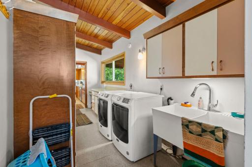 The main-level laundry room offers plenty of room to stay organized, complete with a utility sink and additional cabinetry