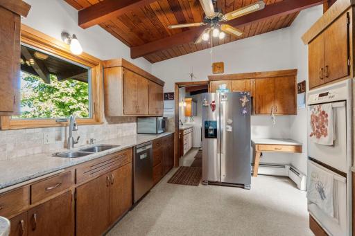 A spacious kitchen offers abundant cabinetry, plenty of workspace, and updated appliances including a newer refrigerator and dishwasher