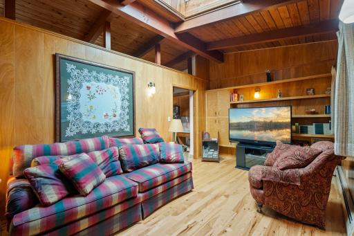 The living room showcases the home’s signature wood ceilings, exposed beams, and warm natural character