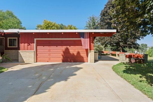 Attached garage and a spacious patio wrapping around the side of the home provide plenty of room for parking and outdoor enjoyment