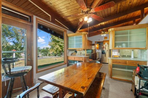 The dining area flows right into the kitchen, all beneath the home’s striking wood ceiling and exposed beams