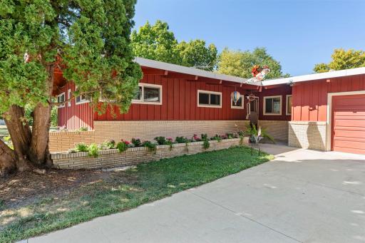 The home’s distinctive red exterior, brick accents and established landscaping give it a character all its own