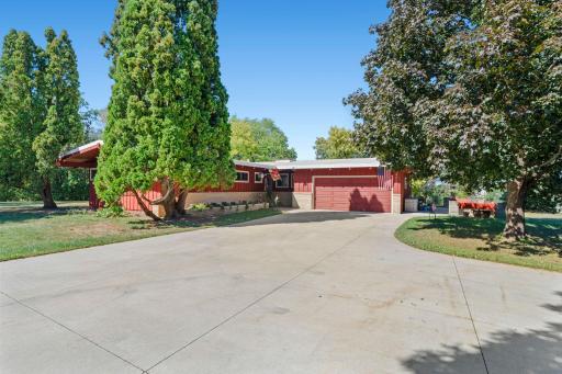 The expansive concrete driveway provides plenty of room for additional vehicles and guest parking