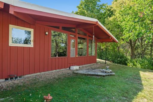 Large windows along the back of the home overlook the peaceful yard, bringing in plenty of natural light, with a convenient door providing easy outdoor access
