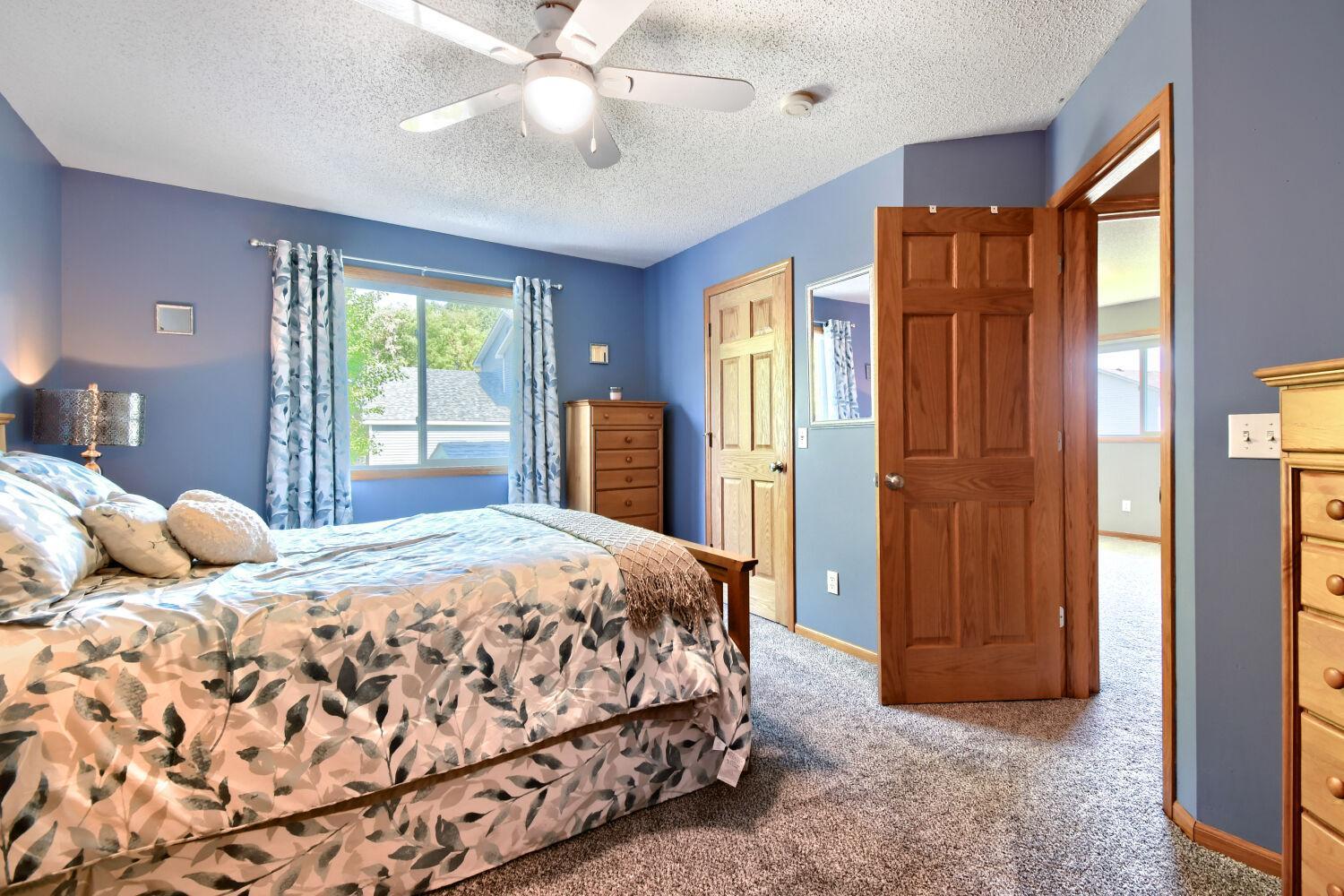 Upper level primary bedroom with new carpet, walk in closet, access to walk-through bath and