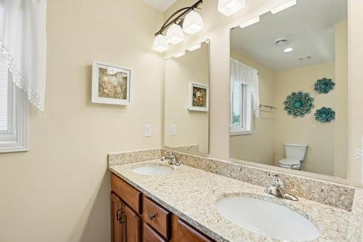 The private 3/4 bathroom includes a large dual sink vanity with storage, a deep linen closet, and luxury vinyl tile floors.
