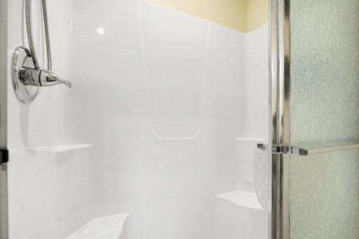 This view of the shower showcases the two benches for convenient seating.
