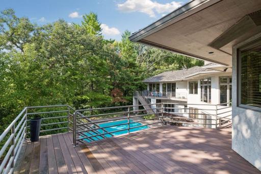 Elevated deck overlooking the pool and wooded setting.