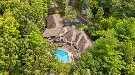 Aerial view showcasing the wooded setting and pool.