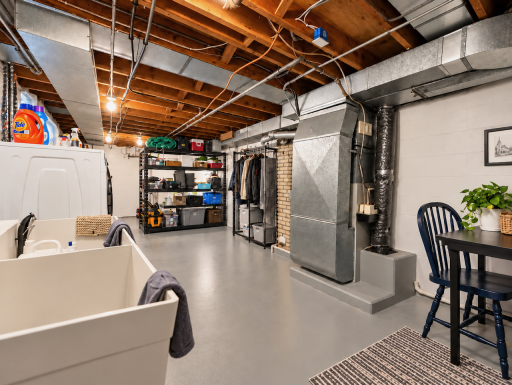Room for the practical side of life. This lower-level utility area has space for shelving, tools and household supplies, with laundry nearby and open floor space to keep everything within reach.