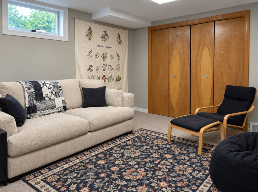 5923âs cozy lower-level retreat with carpeted floors, a high window and closet storage offers space to read or unwind.