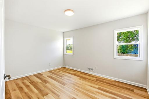 One of five comfortable bedrooms, featuring new flooring, fresh paint, updated windows, and plenty of natural light. With five bedrooms throughout the home, there is flexibility for family, guests, a home office, or a hobby room.