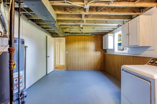 Spacious and functional lower-level laundry and utility room featuring new laundry appliances, built-in cabinetry for extra storage, all-new basement plumbing, and access to the homeâs new central A/C system.
