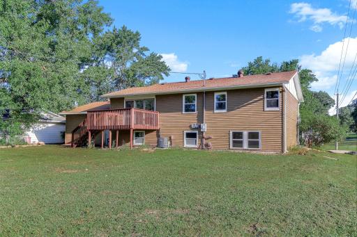 Spacious backyard with mature trees and a raised deck, offering plenty of room for relaxing, entertaining, gardening, or outdoor activities.
