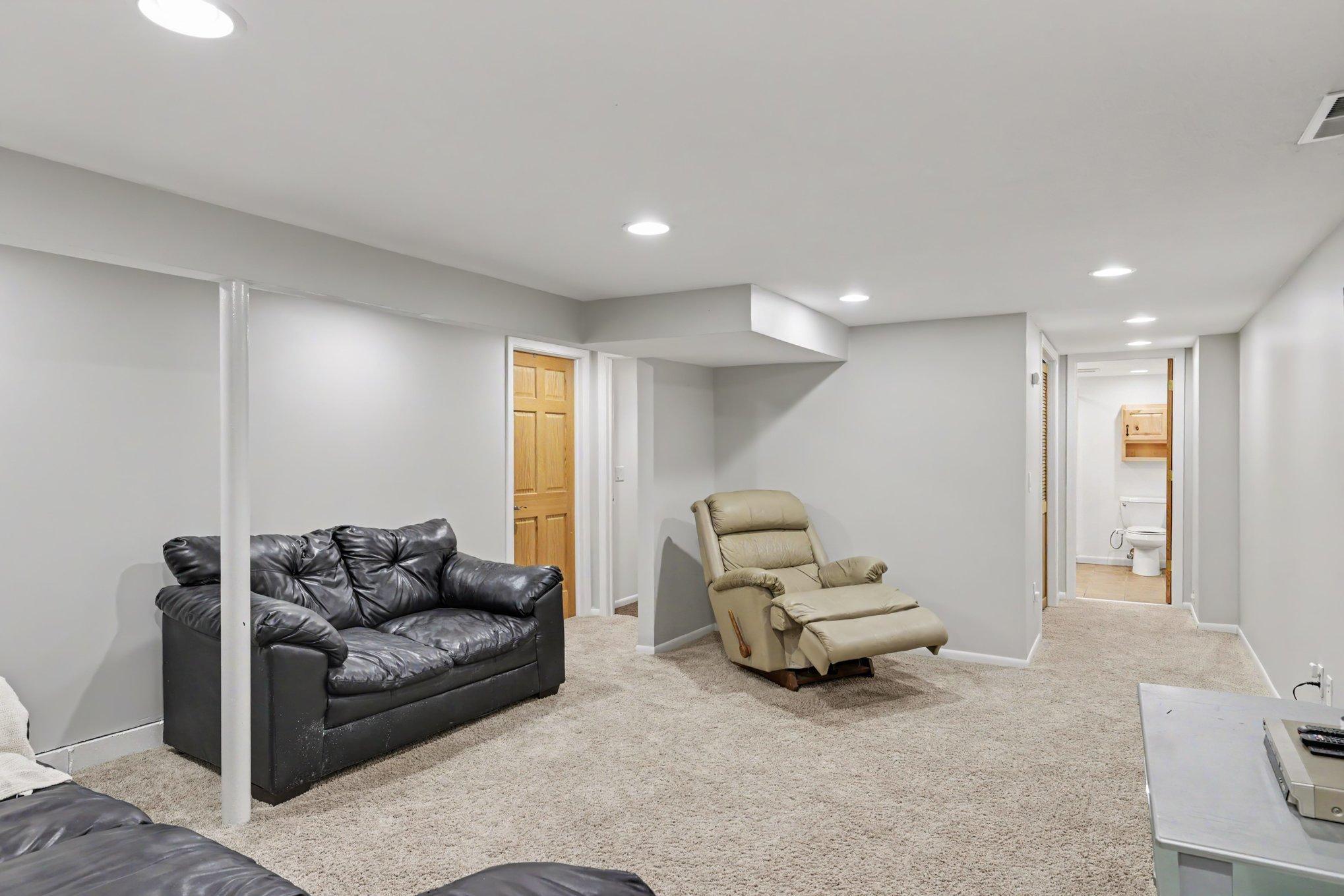 This view of the lower level family room shows the 3/4 bathroom, the utility room and mechanical closet.