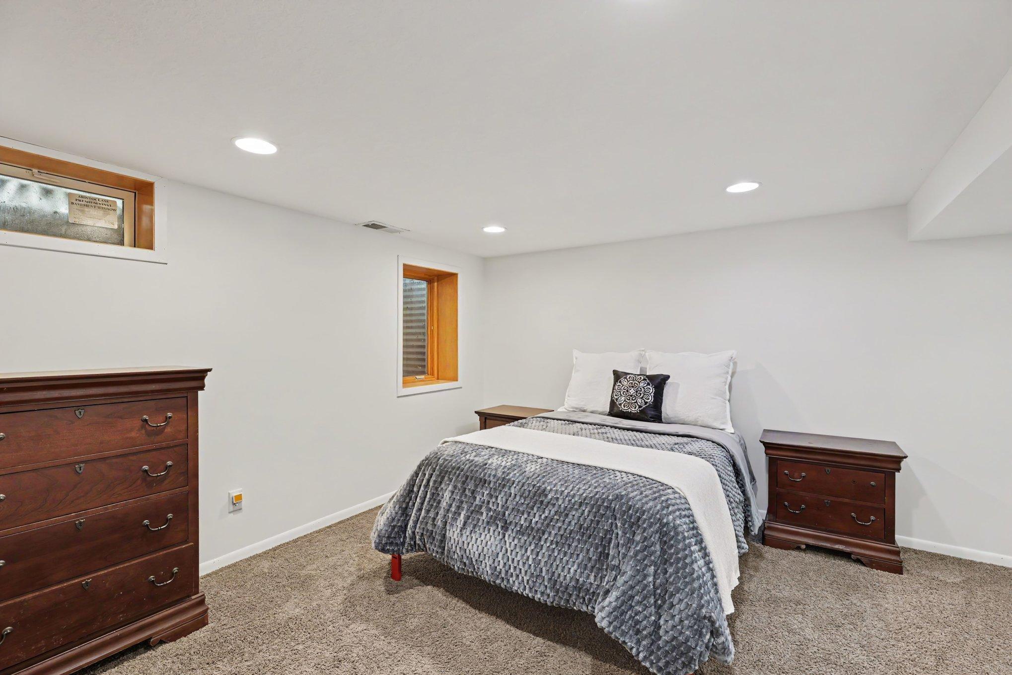 The third bedroom in the lower level includes recessed lights, an egress window, and a spacious closet.