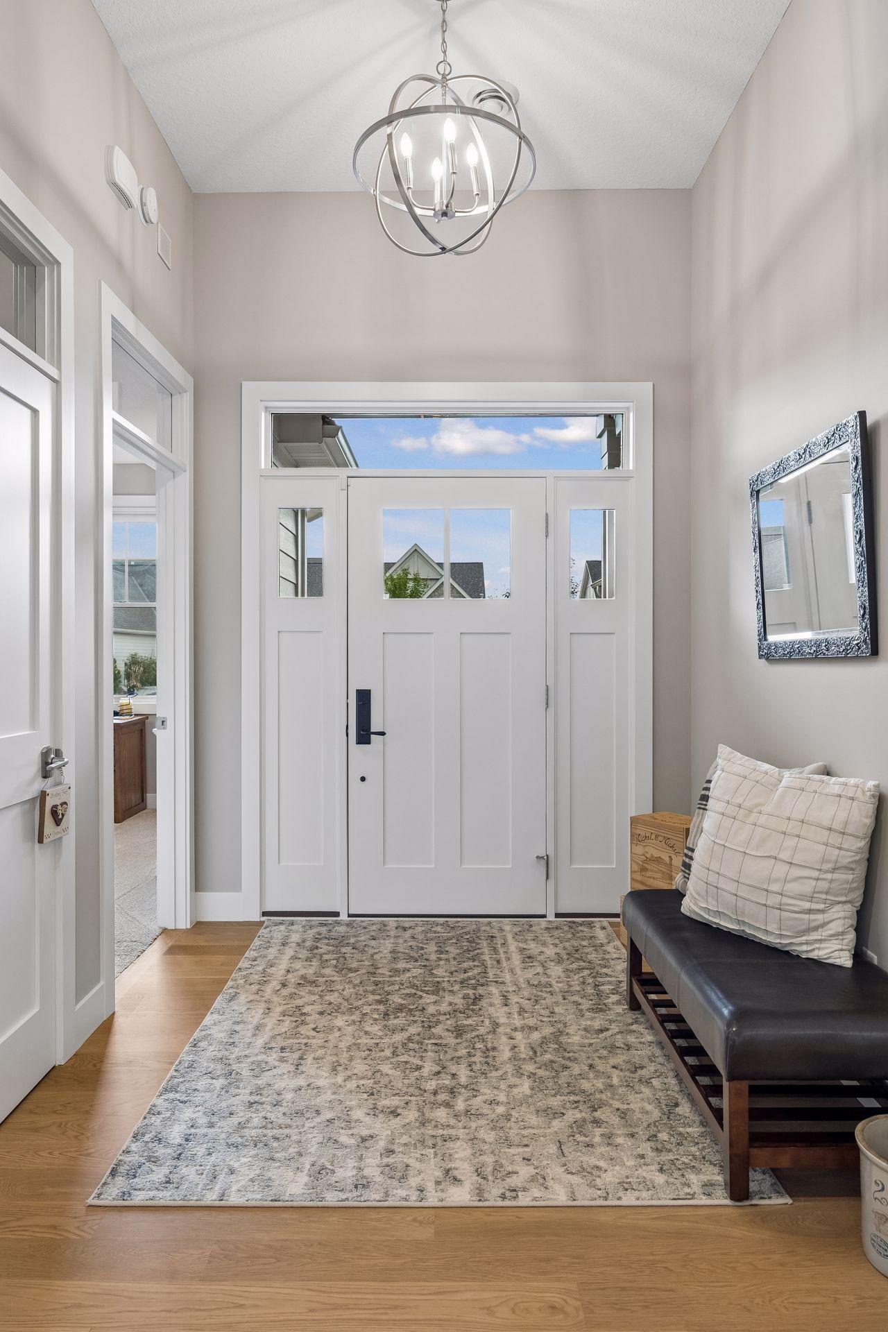 Step inside to a beautiful, light-filled foyer where tall ceilings and windows in the front door create an impressive welcome.