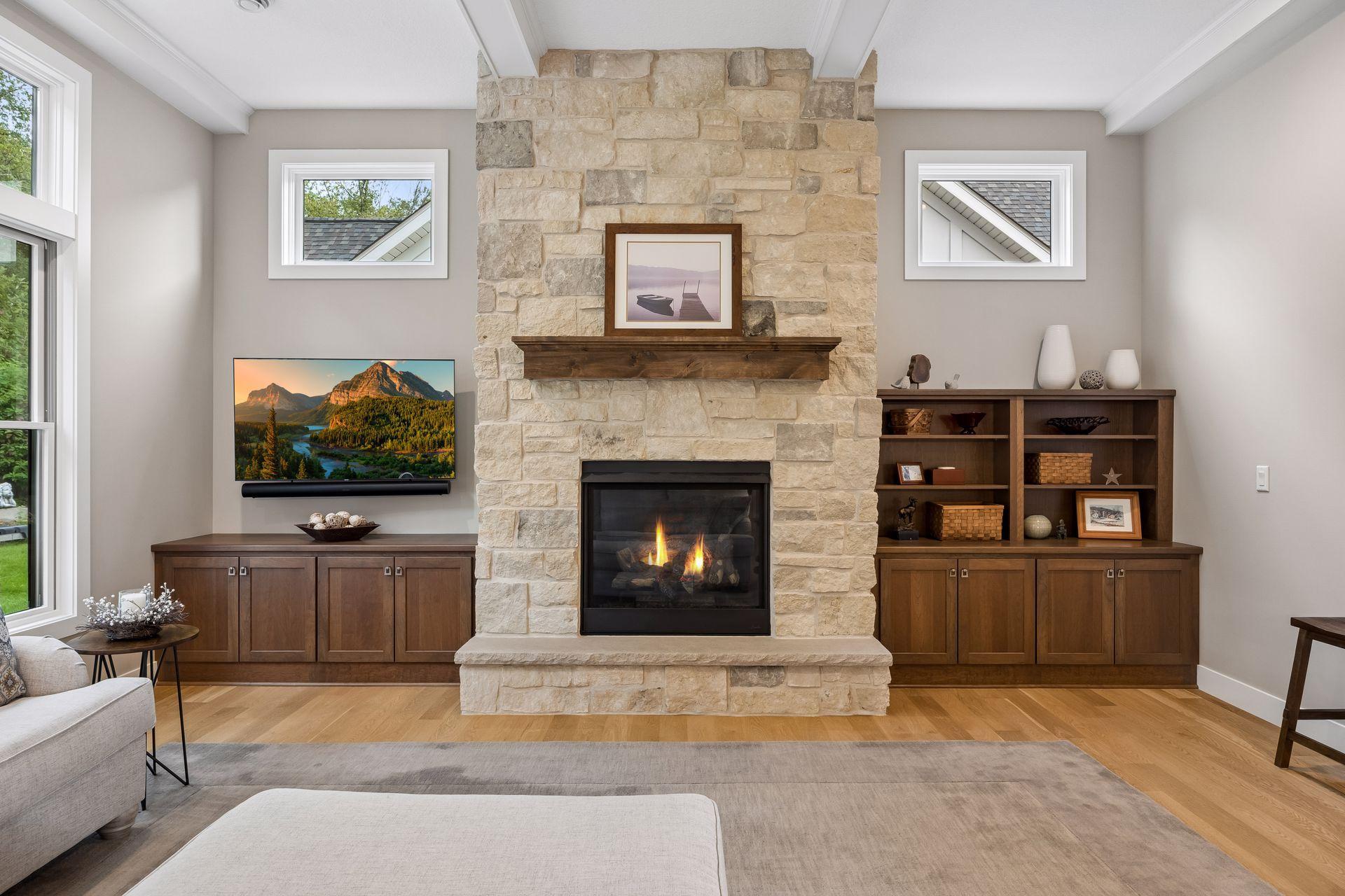 Another look at the stunning stone fireplace, flanked by custom built-ins and windows that make this space feel extra special.