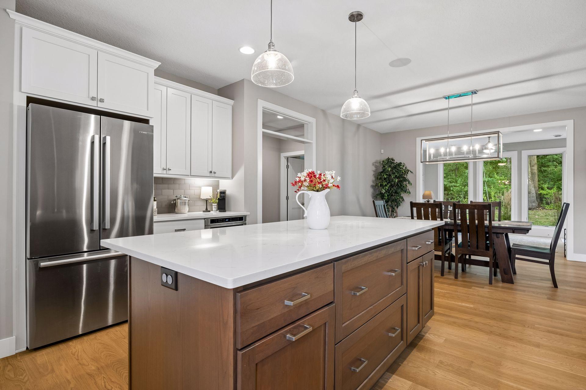 The view from the kitchen sink keeps you connected to the dining area with a glimpse into the beautiful four-season sunroom beyond.