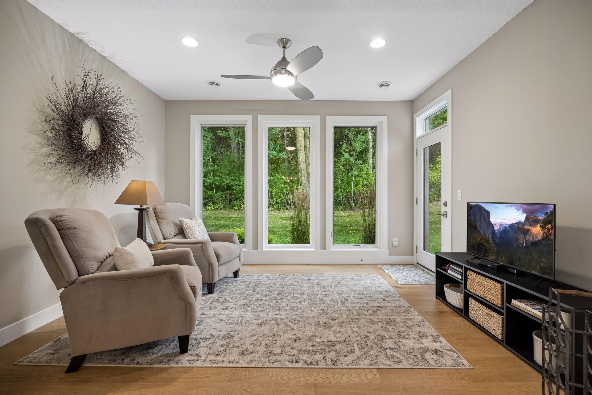 The four-season sunroom is another wonderful spot to relax, surrounded by windows and views of the peaceful outdoor setting.