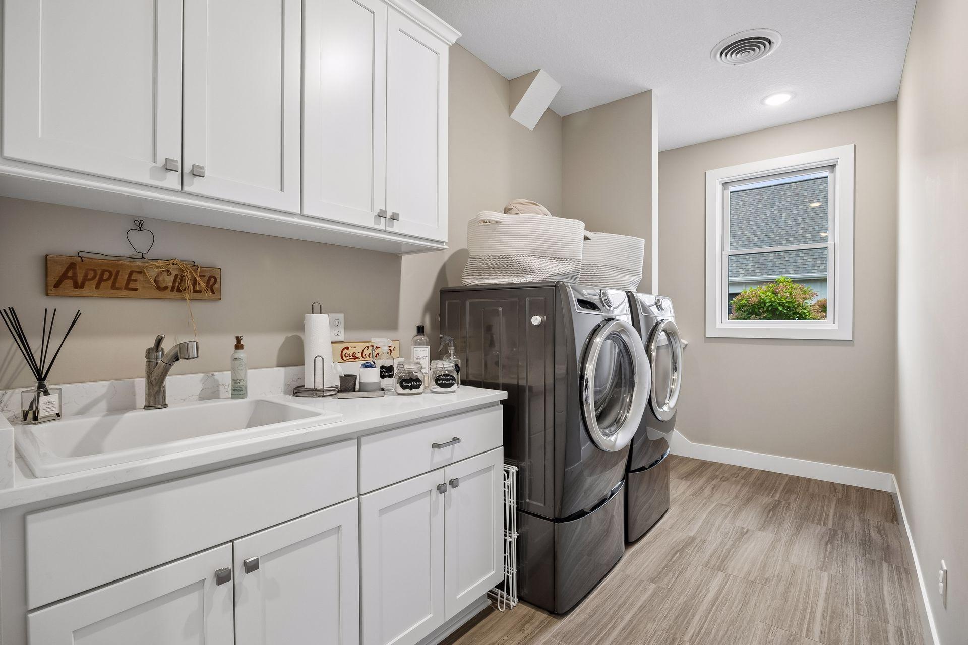 The laundry room features Electrolux washer and dryer, a utility sink, and hallway leading to the bonus space above the garage.