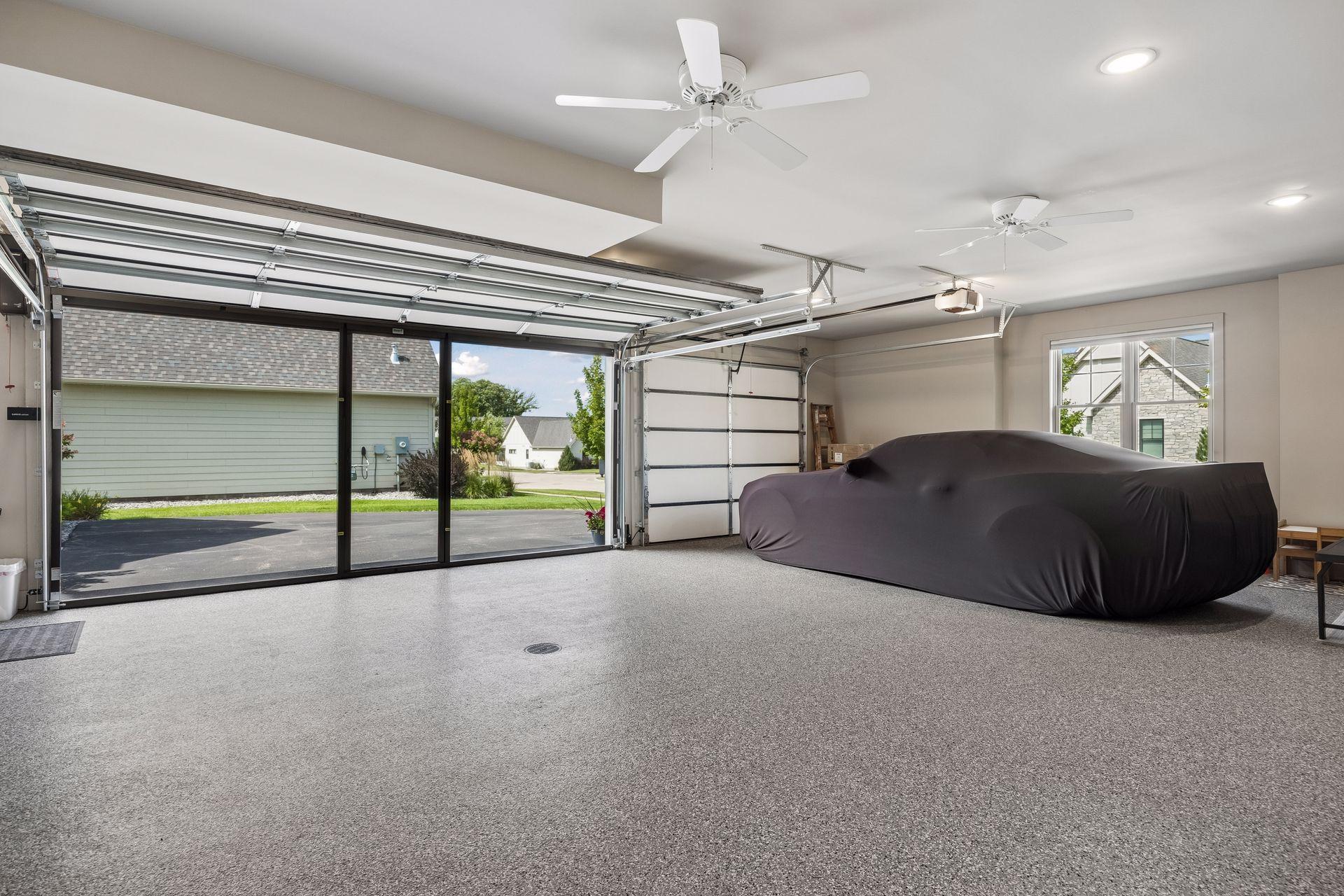 The garage of your dreams! This three-car space features heated epoxy floors, floor drains, ceiling fans, a wash sink, and a magnetic garage screen—perfect for turning the garage into an additional hangout space during the warmer months.