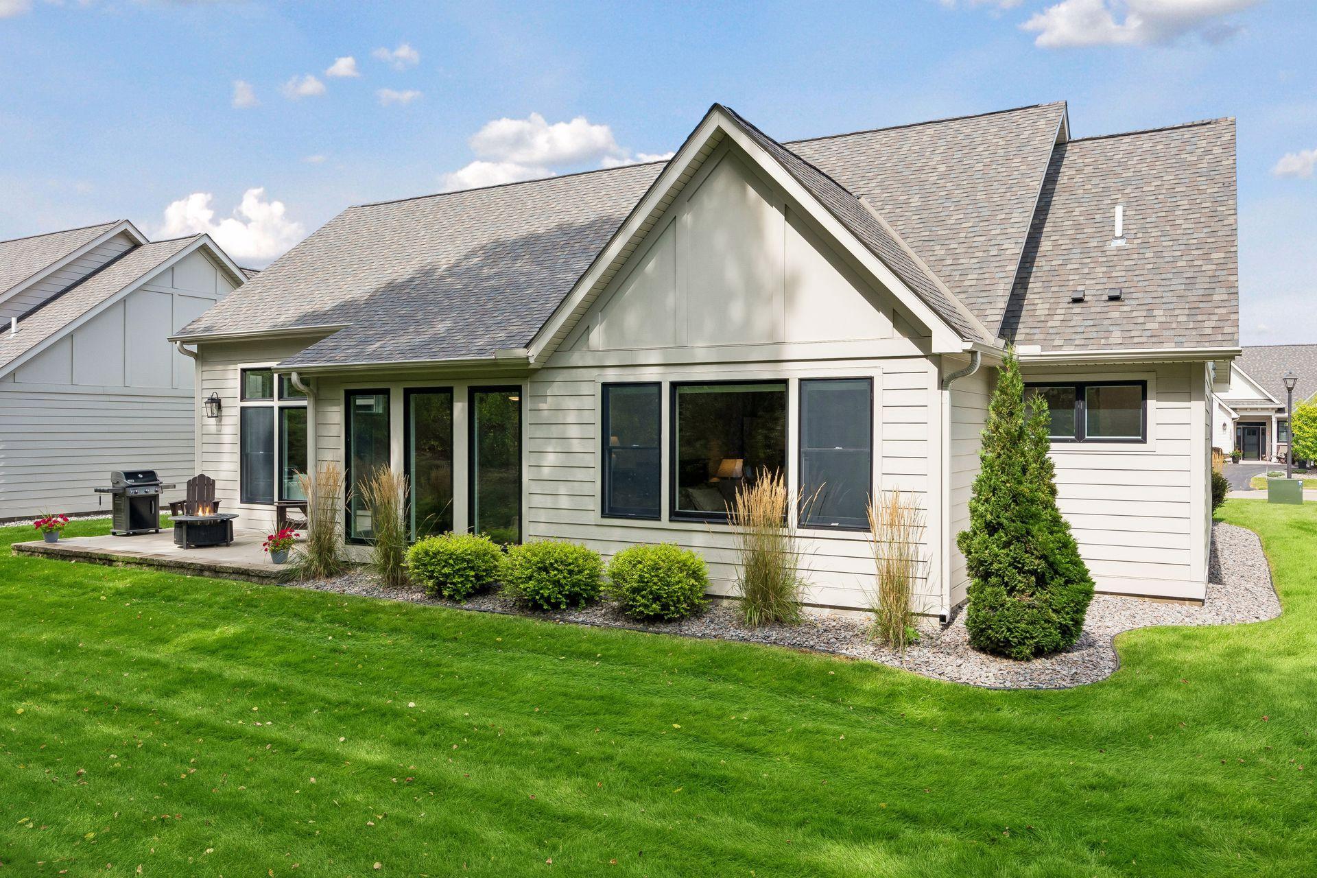 Beautiful landscaping surrounds the backyard, creating an inviting outdoor space with mature trees beyond.