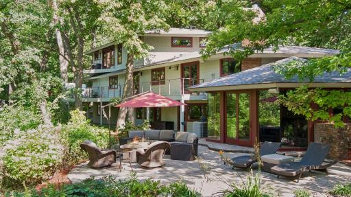 Private outdoor living area with paver patio, seating, and direct connection to the surrounding landscape