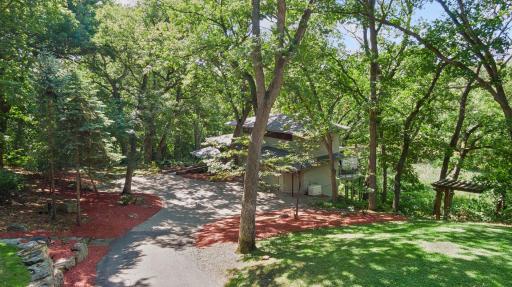 Private, tree-lined approach to this distinctive John Howe-designed Mid-Century Modern home, surrounded by mature trees and thoughtfully integrated into its natural setting.