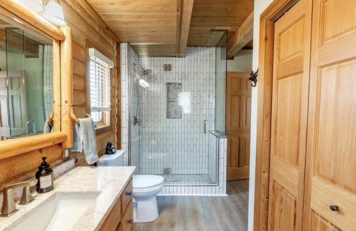 photo 5 - Beautifully updated main bath with quartz countertop and custom tile shower.jpeg