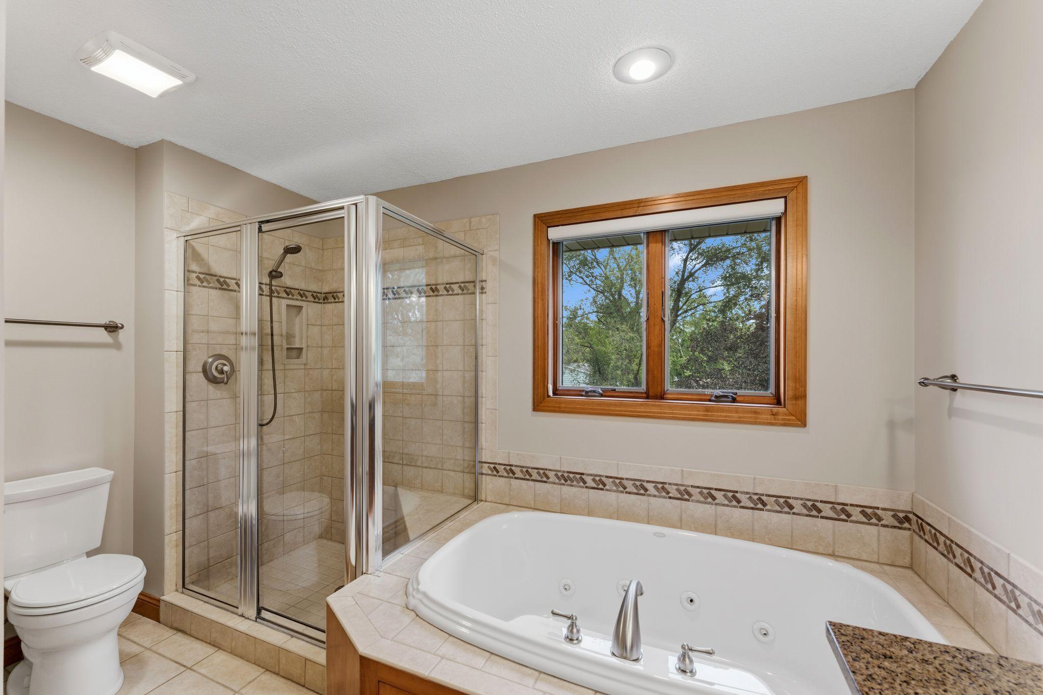 Primary private bathroom!! Separate shower with updated tile! Soak all of your cares away in your jetted whirlpool tub!! Enjoy in-floor heat as you get ready for the day!!