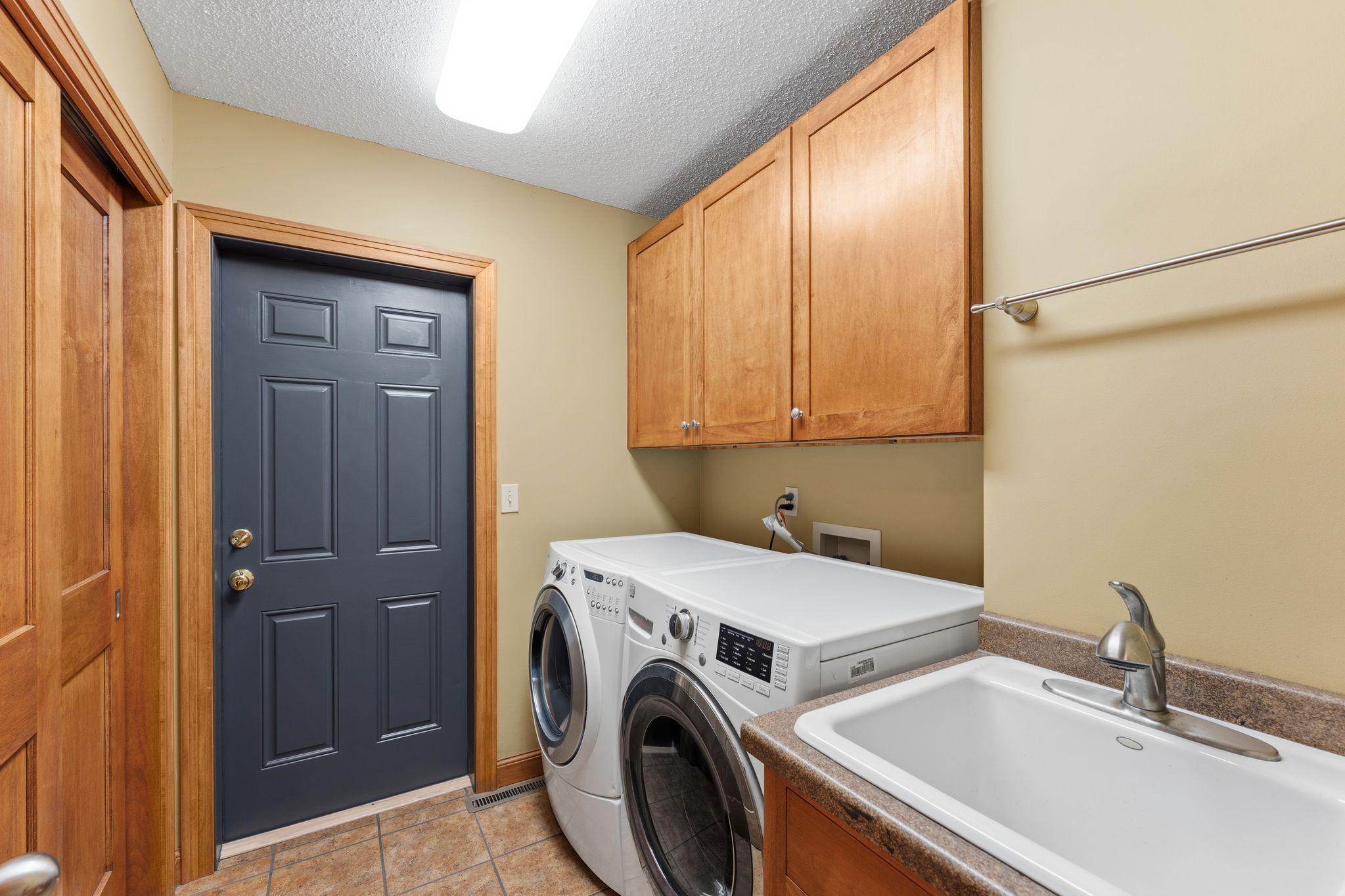 Main floor laundry room/mudroom and garage access. Updated cabinetry, solid-wood sliding closet doors, tile flooring, front-load W/D and a utility sink!!