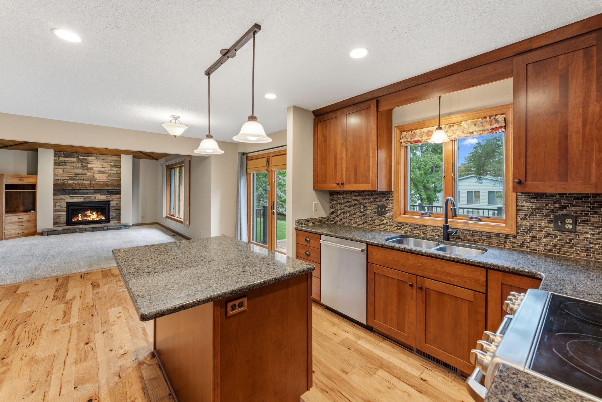 Kitchen island + dinette space - perfect for casual dining and conversation! Wonderful open-concept with the family room adjacent to the kitchen! Step out the doors to the AMAZING deck!