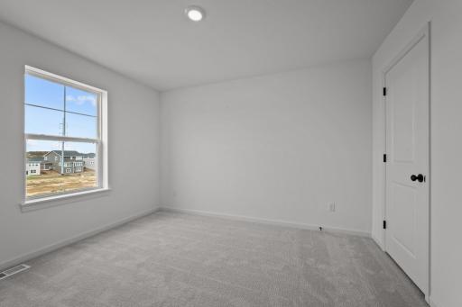 Comfortable secondary bedroom in the McBee plan ideal for guests or family use. Images are from a similar home, interior selections may differ