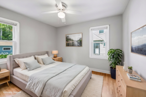 Virtually staged main floor bedroom with original hardwood floors and fresh paint.