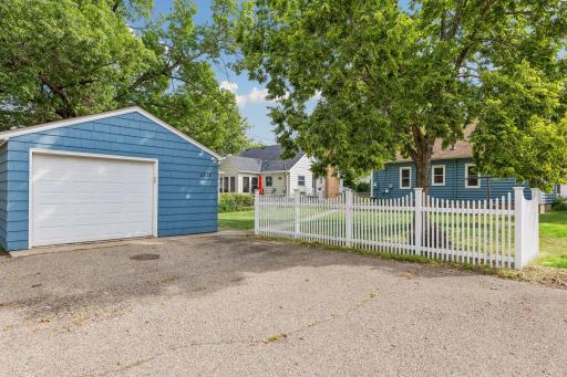 Oversized one car detached garage with partial decorative corner fence