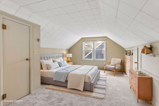 Virtually staged. The spacious upstairs primary bedroom features tall ceilings, brand-new carpeting, built-in drawers, and a generous closet.