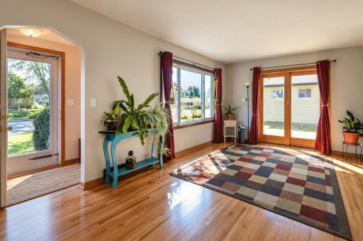 Warm and inviting living room featuring beautiful hardwood floors and an abundance of natural light, creating a bright and comfortable space for relaxing and entertaining.