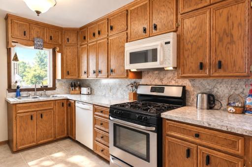 Upper cabinets provide space for extra kitchen appliances and gadgets. The window above sink overlooks the backyard.