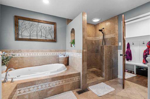 This huge bathroom has doors to the primary bedroom and the hallway.