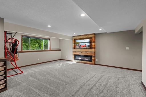This lower level family room has an electric fireplace,