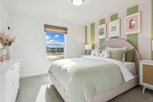 (Photo of decorated model, actual home's finishes will vary) One of three generously sized secondary bedrooms with spacious closets.