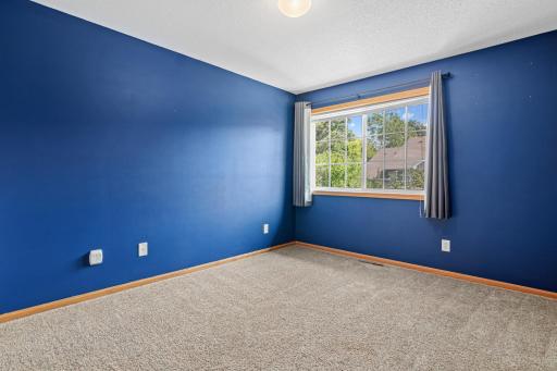 Second bedroom with a view of the quiet street and woods.