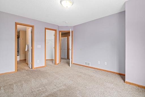 Primary bedroom with view of walk in closet and primary bathroom