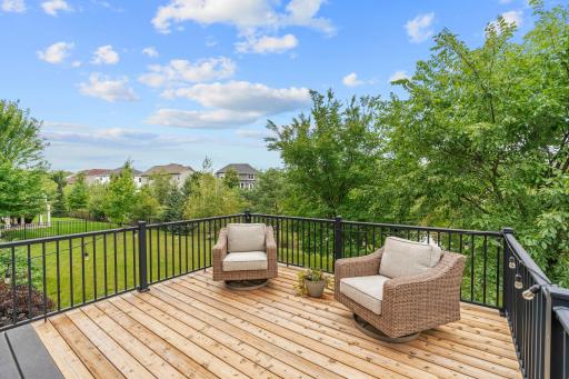 Walk out to the deck overlooking ample flat green space + beautiful pond views