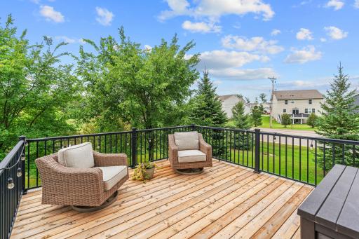 Walk out to the deck overlooking ample flat green space + beautiful pond views